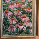 A painting of pink flowers in a gold frame.