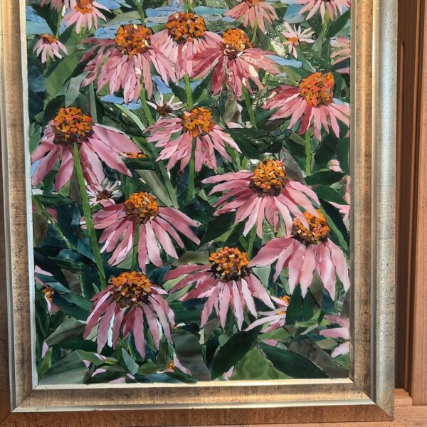 A painting of pink flowers in a gold frame.