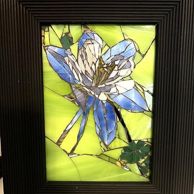 A picture of a blue flower in stained glass.