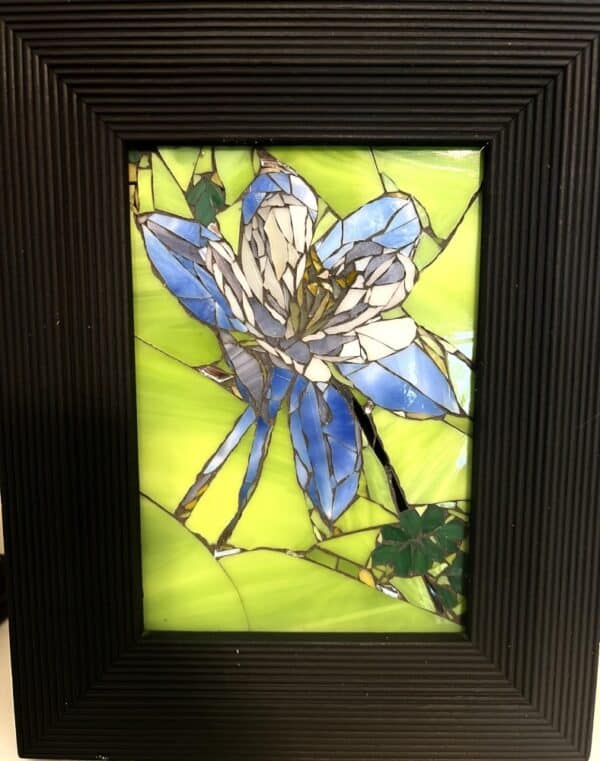 A picture of a blue flower in stained glass.