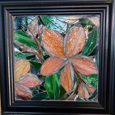 A painting of leaves and flowers in a frame.